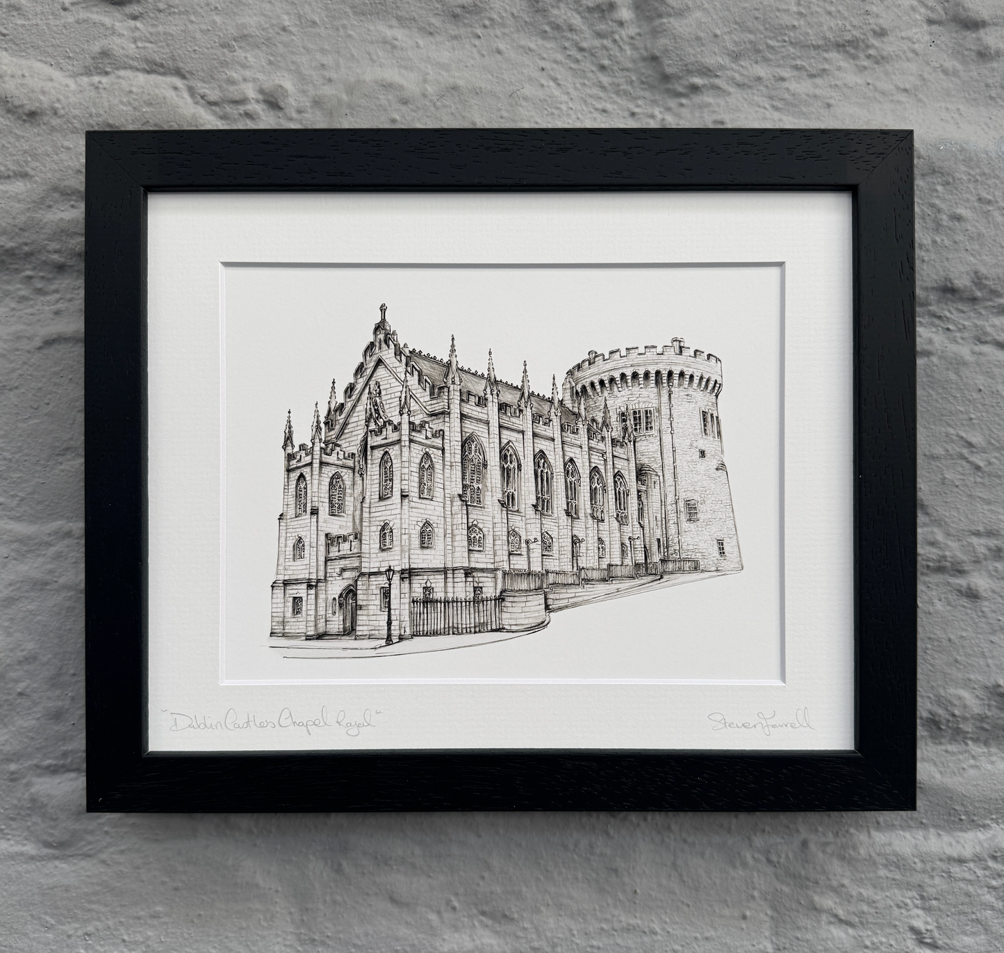 Framed black and white print of a castle on a stone wall background