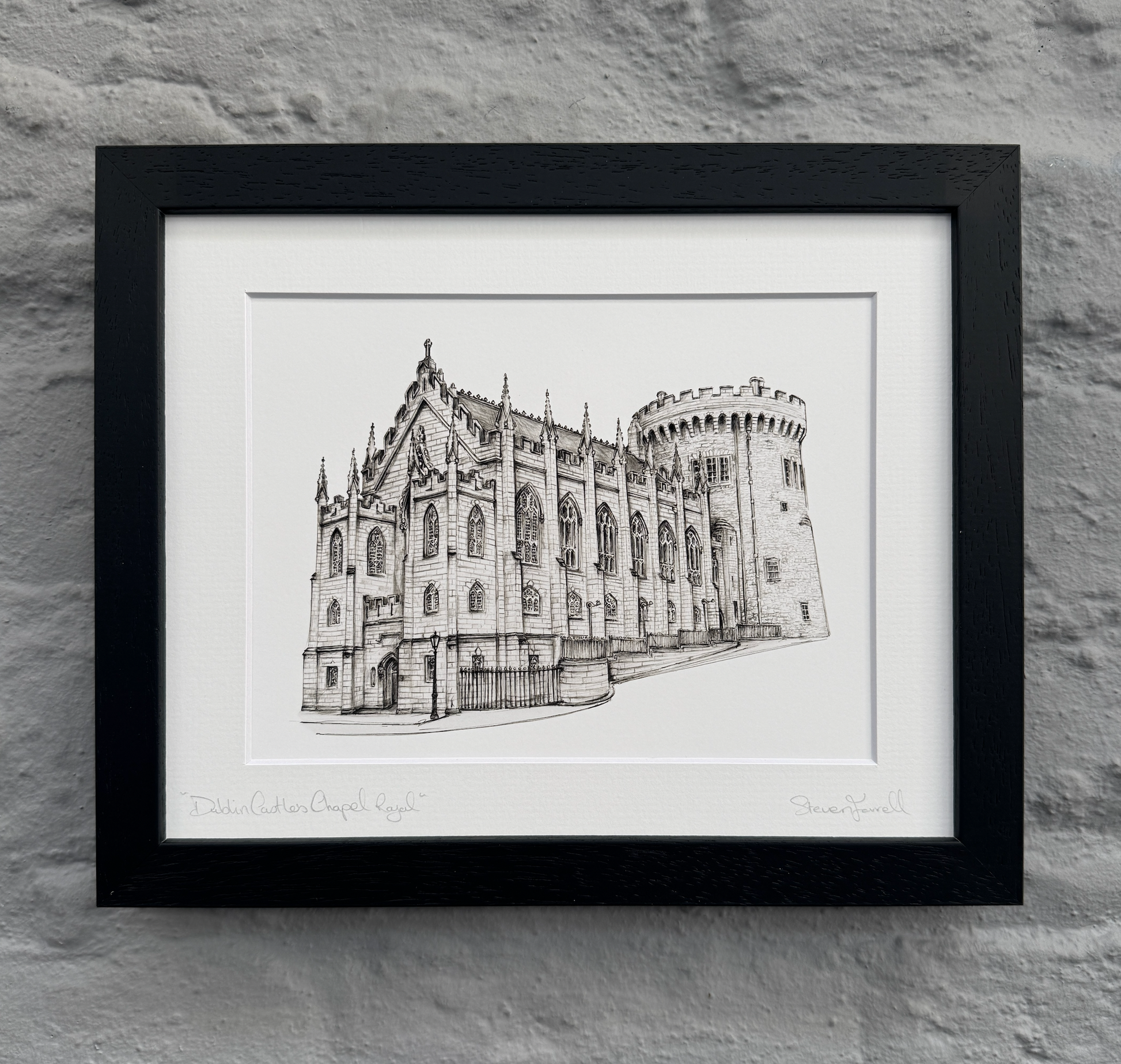 Framed black and white print of a castle on a stone wall background