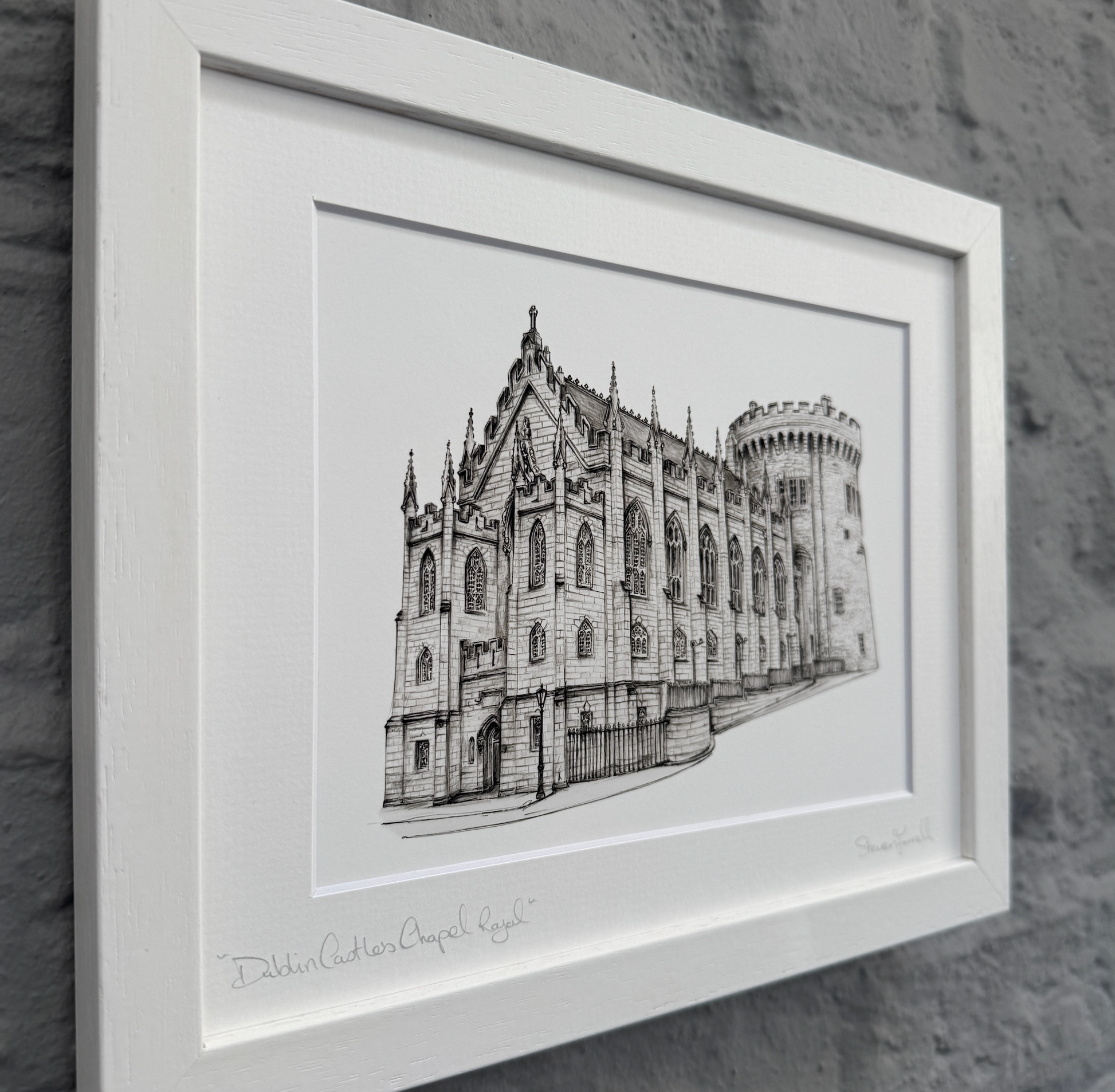 Framed black and white illustration of a cathedral on a stone wall background